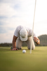 Frustrated golfer lamenting for missing his shot on the green a few inches from the hole.