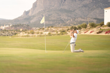 Obraz premium Angry golfer lamenting for missing his shot on the green a few inches from the hole.