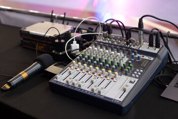 Workplace with audio mixing console and microphone of sound engineer control music and light in...