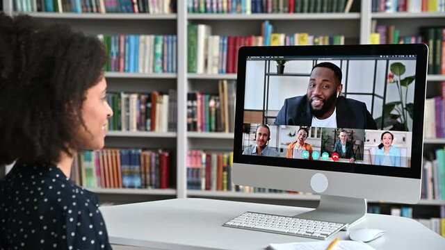 Video call, online education. African American happy female student, learning distantly, watches an online lecture, taking notes, multiracial smiling people on a computer screen, virtual communication