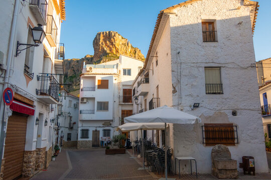 Alley ofold houses surrounded by rocky cliffs under the sunlight in Sot de Chera, Spain