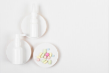 Medicine packs with the pile of pills on white corrugated paper background. Medicine or pharmacy concept. Copy space. Flat lay.