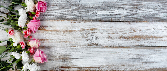 Left border of real bouquet flowers on rustic wooden planks for mothers day or valentines holiday