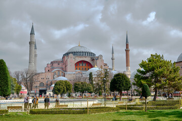 Overcast and cloudscape above the hagia sophia. Ancient hagia sophia mosque by taking photo from Sultanahmet square and green grass with many people and tourist walking. . istanbul. Turkey.