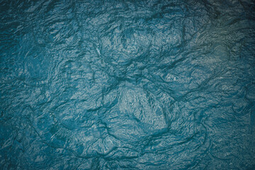 Texture of dark blue calm water of lake. Meditative ripples on water surface. Nature minimal background of deep green lake. Natural backdrop of clear dark turquoise water. Full frame of lake fragment.