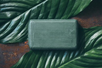 A piece of natural soap made from oils on green leaves, mockup - 433147886