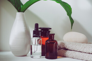 Home spa, cosmetic oil in a bottle, wooden bowl on a white table - 433147897