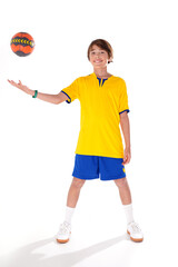 Full length photo of a young sporty boy holding handball and smiling to the camera