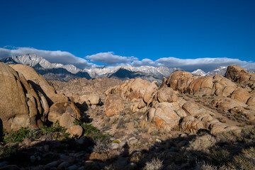 Skyline view of lenticular cloud, mountains, rocks and arch. Alabama Hills, California