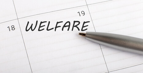 Text welfare on calendar planner to remind you an important appointment with a pen on isolated white background.