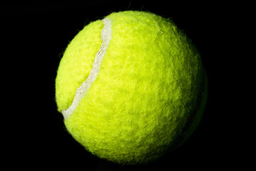 Isolated Optic Yellow Tennis Ball on Black Backdrop