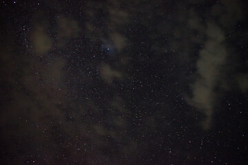 beautiful night time picture of bright stars and white clouds