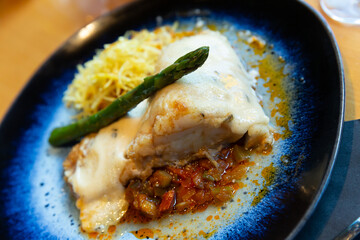 Baked cod fillet on vegetable ratatouille with chorizo, crisp shoestring fries, asparagus and...