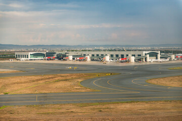 Paphos Airport in Cyprus. Planes on the runway and at the hangars. Taxiway to the airport terminals. One plane at many airports.