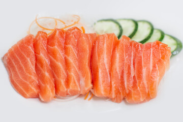 raw salmon red fish with vegetables on white plate