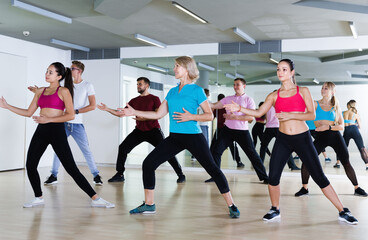 Positive people of different ages dancing in modern studio