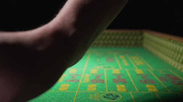 This POV video features a gambler's hands exchanging a pile of crumpled up cash with a casino dealer for gambling playing chips on a craps table.