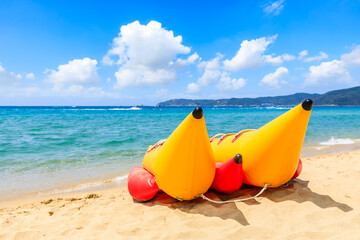 Yellow banana boat by the blue sea.