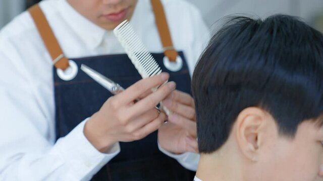 To cut the hair with scissors by cutting the hair. Professional hairdressers to design hair for costomer. Beauty salon or barber shop business concept.