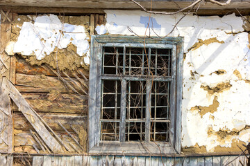 Fragments and parts of the walls of an old building with elements of plaster, metal, wood, paint, subject to destruction by time and weather conditions.
