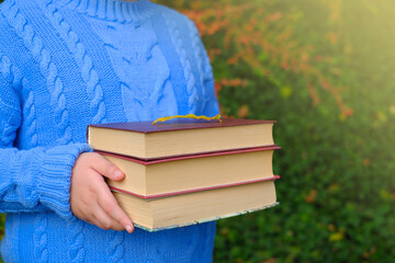 Back to school. Autumn books. School time.A stack of books  in children's hands. Education and...