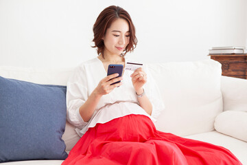クレジットカードを使いネットショッピングをする妊婦の女性
