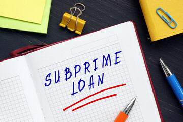  SUBPRIME LOAN sign on the page. A subprime loan is a type of loan offered at a rate above prime to individuals who do not qualify for prime-rate loans.
