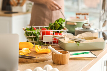 Fresh food and notebook on table in kitchen