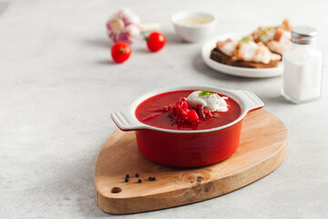 Delicious fresh red borscht, dark bread with lard and salt on kitchen table. Copy space.