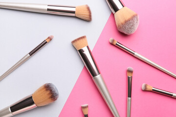 Set of makeup brushes on color background