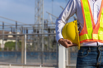 A young engineer standing with a yellow hat in his hand at the main power station.