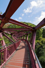渓谷に架かる湾曲した赤い鉄橋の風景