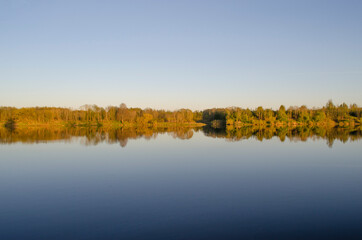 wide river at sunset and trees on the shore