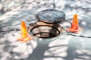 Open sewer manhole on the asphalt road