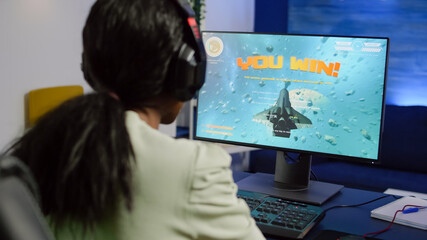 African streamer woman winning space shooter video game during esport tournament playing with joystick. Pro gamer using wireless controller, professional mouse and headset at night in streaming home © DC Studio