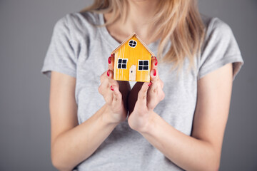 woman holding wooden house model