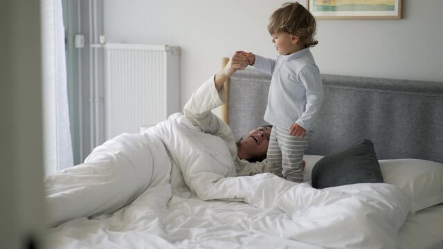 Cute little baby toddler bouncing in bed