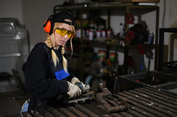 Photo of pretty woman in overalls holding an angle grinder