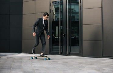 Handsome young business man with his modern longboard