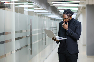 Black Businessman using laptop for analyzing data stock market, forex trading graph, stock exchange trading online, financial investment concept. close up
