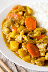 Homemade Japanese Chicken Curry  on a white plate, side view. Close-up.