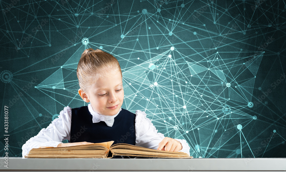 Wall mural smiling little girl sitting at desk with open book