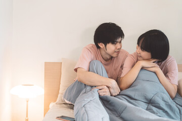 Happy young adult asian lover couple living together in bedroom at home.