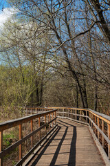 Wooden bridge over the river in the city park of Moscow, Sviblovo district. Spring landscape.