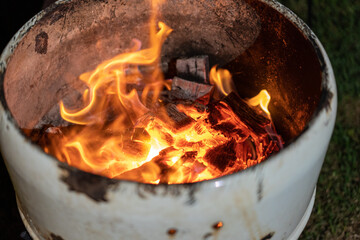 backyard fire pit made with metal barrel, campsite barrel fire pit burning to keep us warm in winter