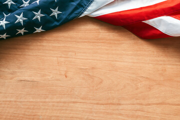 Twisted USA flag on wooden background as copy space