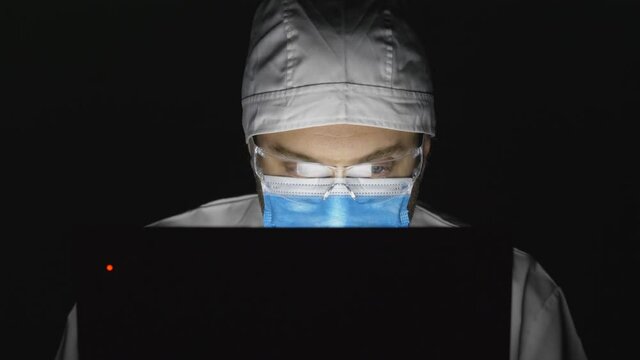 Portrait of man doctor with mask look at laptop late night