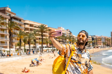 A young tourist with the phone on Playa del Cura in the coastal city of Torrevieja, Alicante, Valencian Community. Spain, Mediterranean Sea