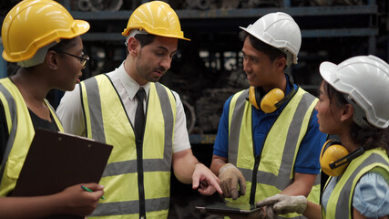 group of diversity warehouse worker meeting and checking list inventory in industry factory . eastern manager, african american clerk clipboard , asian man using tablet . teamwork of multiethnic