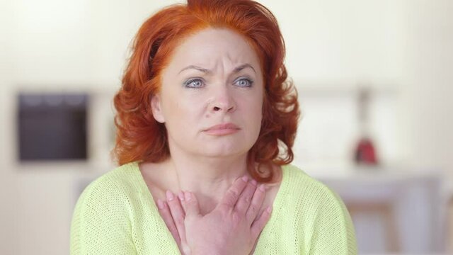 Close-up portrait of stressed beautiful redhead woman having panic attack looking at camera and around. Anxious Caucasian lady with worried facial expression posing indoors. Mental health
